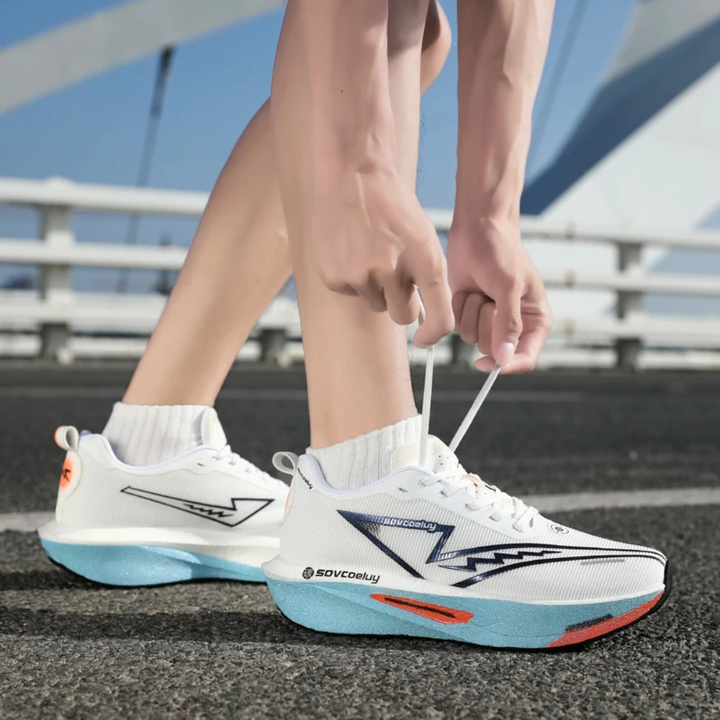 Person tying white blue Apex Forge Lightweight Marathon Sneakers on a road.