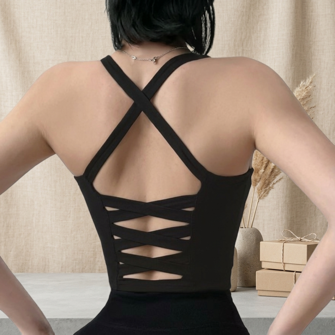 Person wearing a black dress with a unique back design against a neutral background