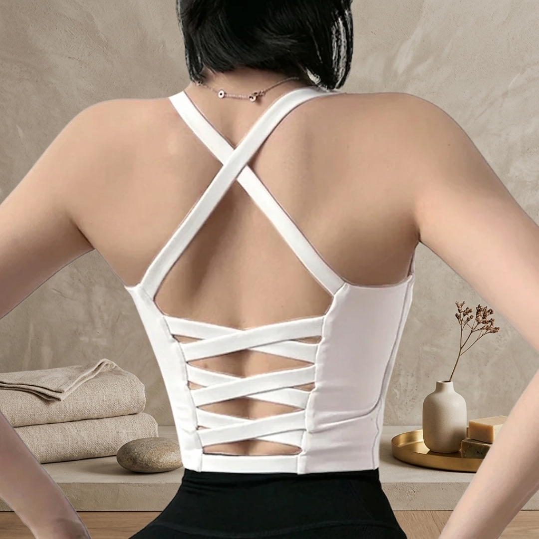 Person wearing a white strappy top with a neutral background