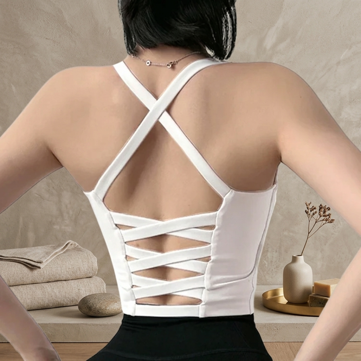 Person wearing a white strappy top with a neutral background