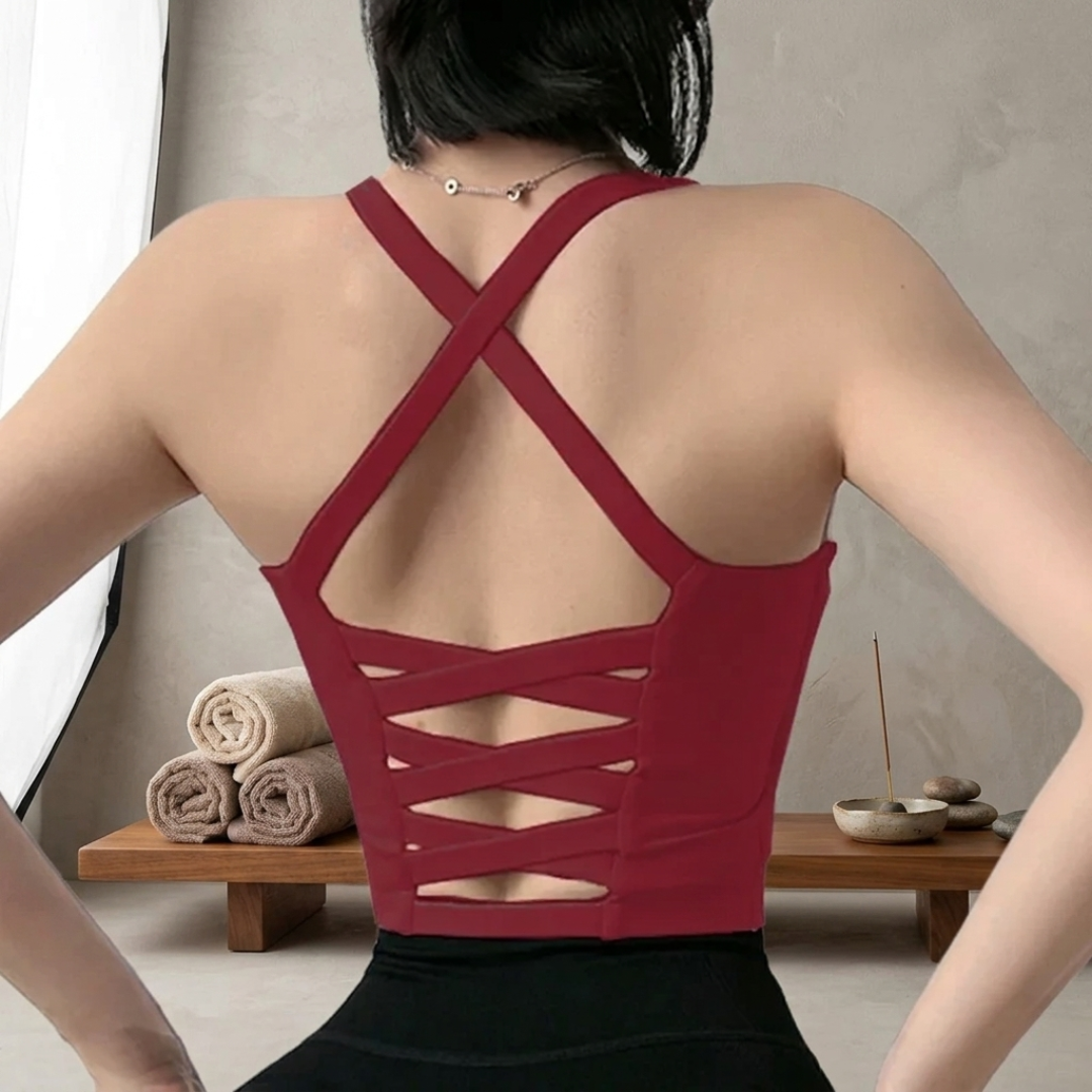 Person wearing a red strappy top with a neutral background