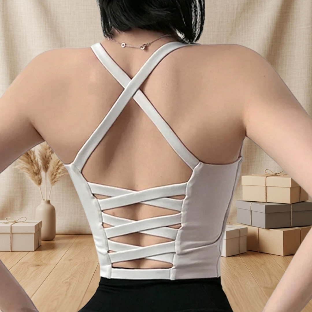 Person wearing a gray strappy top with a neutral background