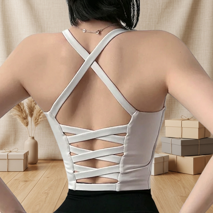 Person wearing a gray strappy top with a neutral background