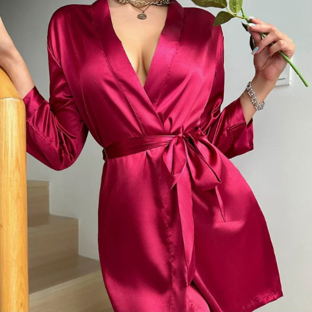 Person wearing a red Belladonna Satin Allure Robe holding a plant indoors.