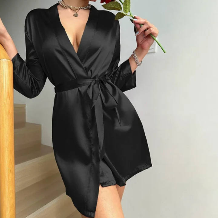 Person wearing a black Belladonna Satin Allure Robe holding a rose, standing on a staircase.