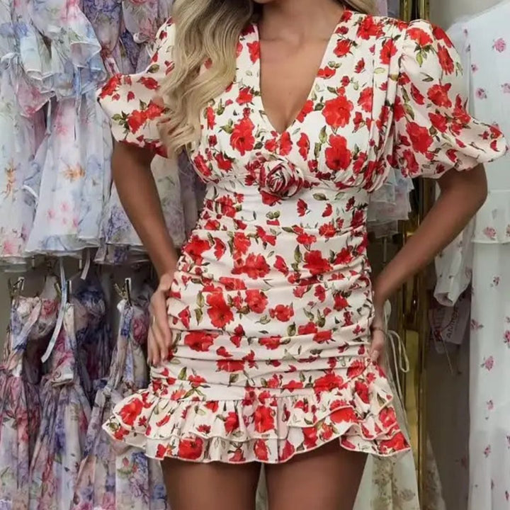Woman wearing a red and white floral dress in a clothing store.