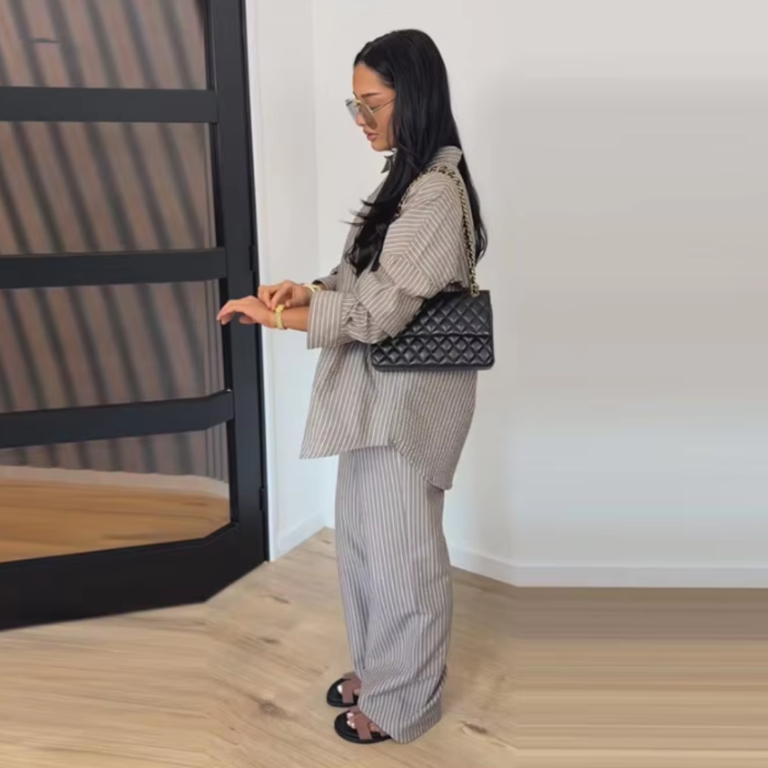 Woman in a Gray Celeste Minimal Power Set holding a black handbag in a minimalistic room.
