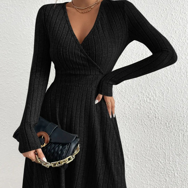 Black ribbed dress worn by a person against a white background