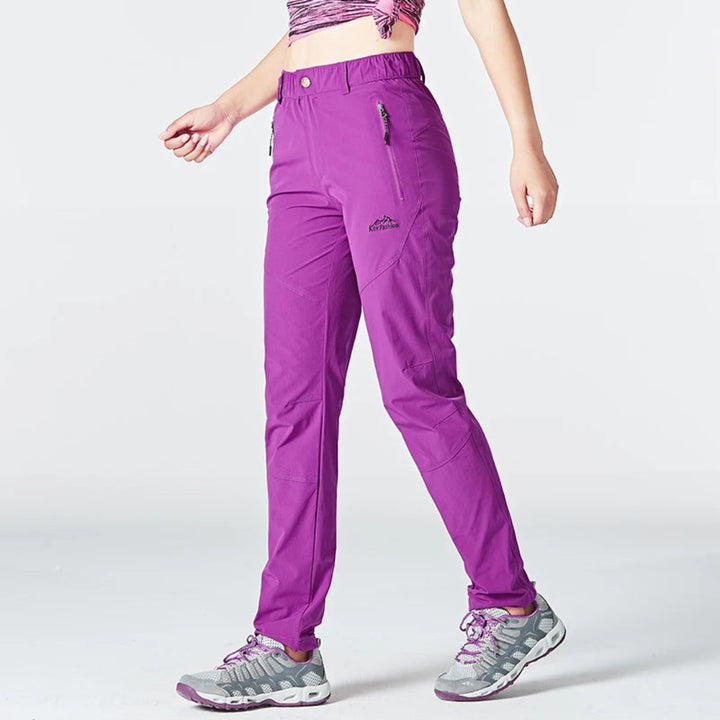 Purple hiking pants worn by a person on a white background