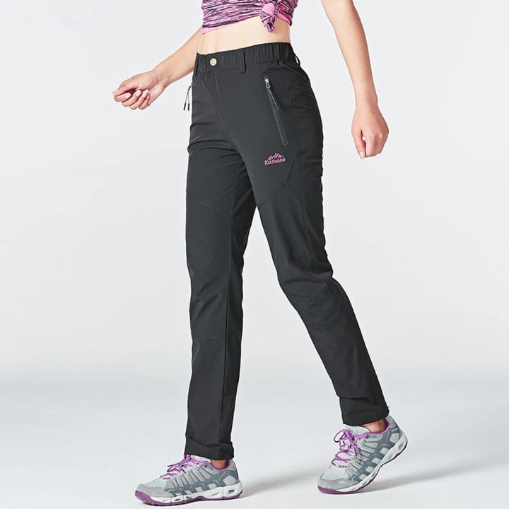 Person wearing black pants with a visible brand logo on a white background