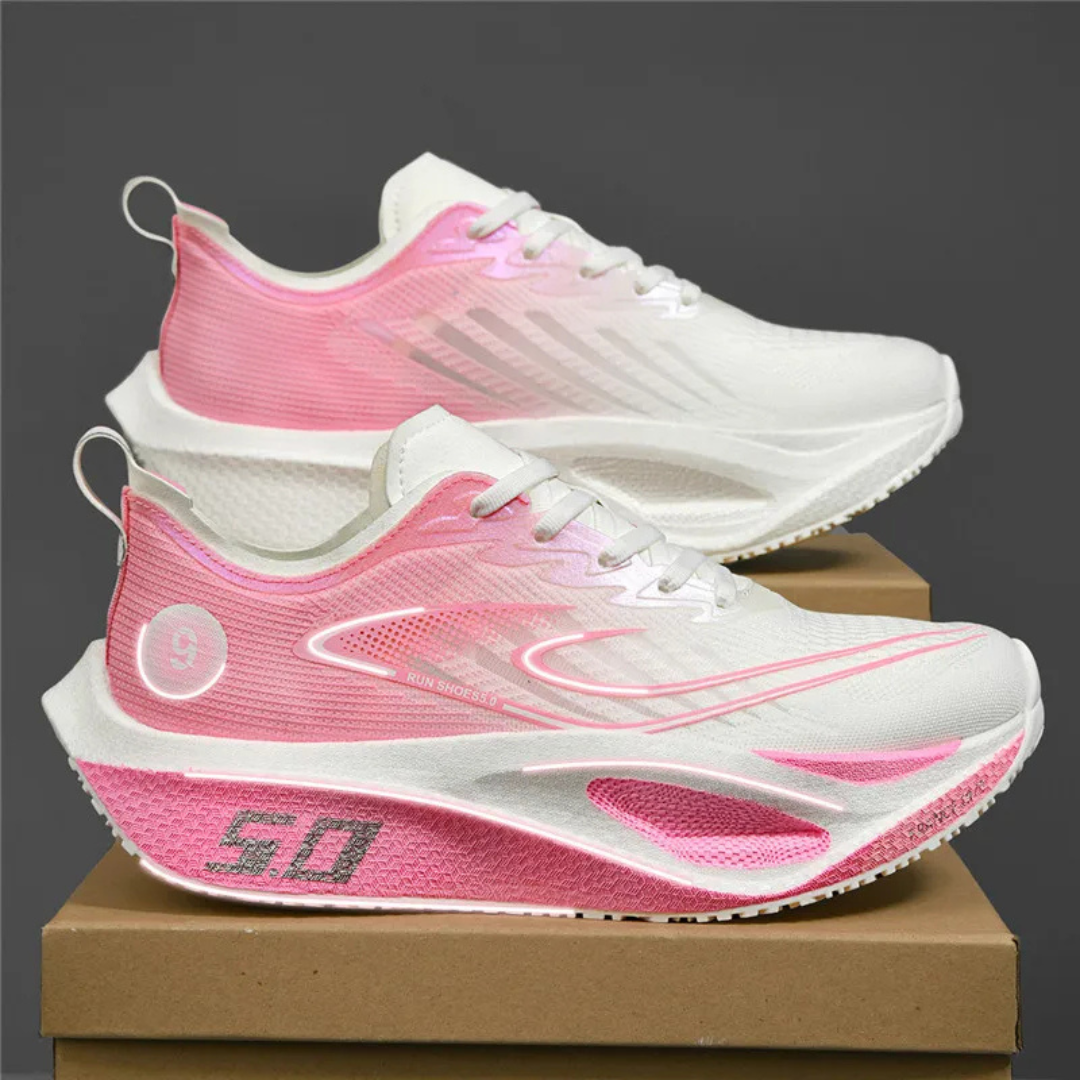 Pink Kryza Aero Pulse Marathon Sneakers stacked on a brown box with a dark background