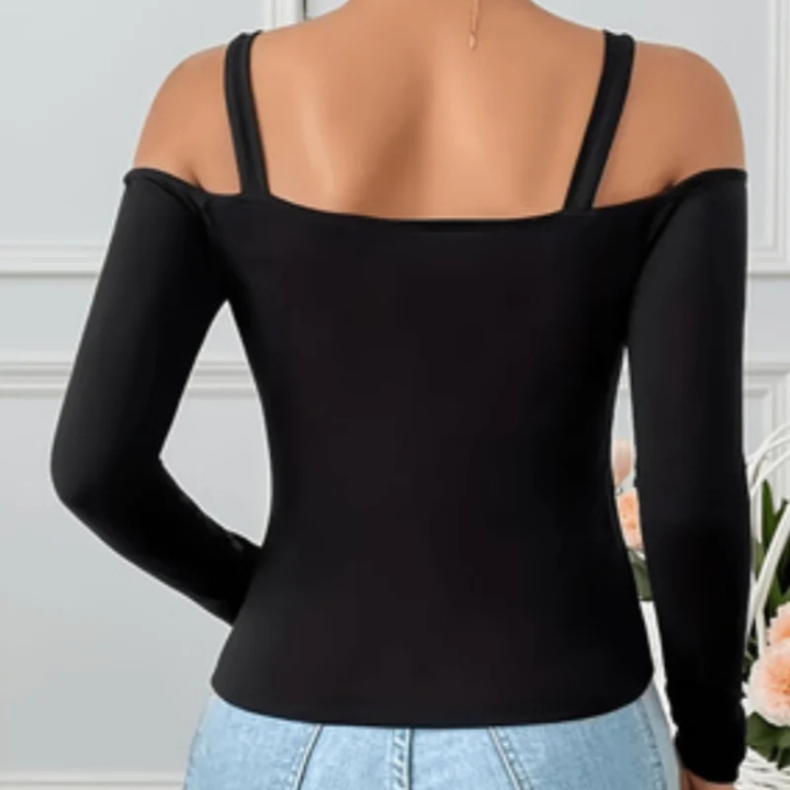 Black long-sleeve top worn by a person with a blurred background