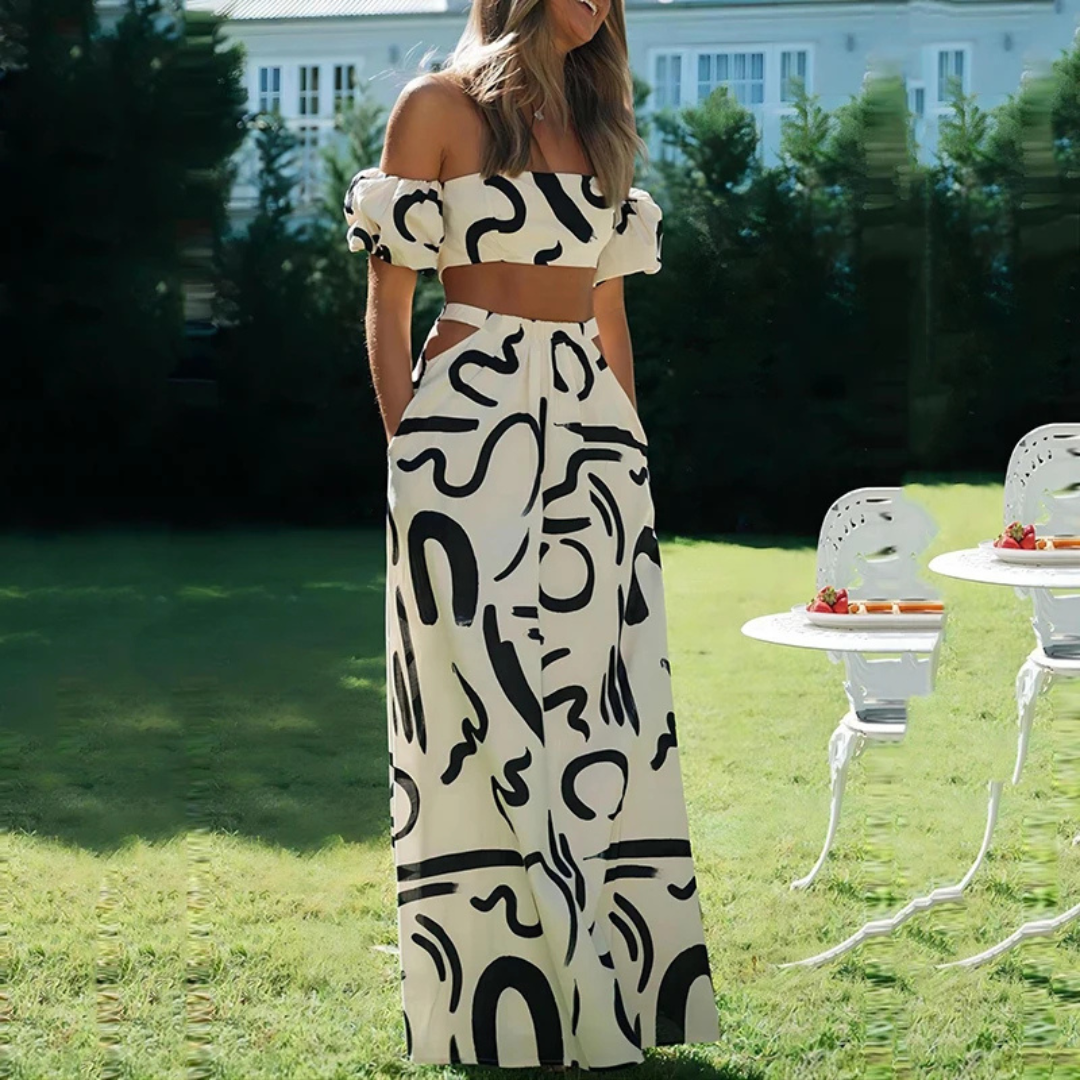 Woman wearing a black and white patterned dress standing outdoors.