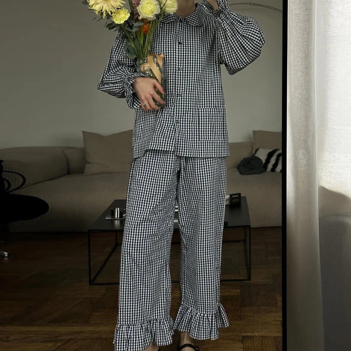 Person wearing a Black Nova Sharp 2-Piece Set holding flowers in a living room.