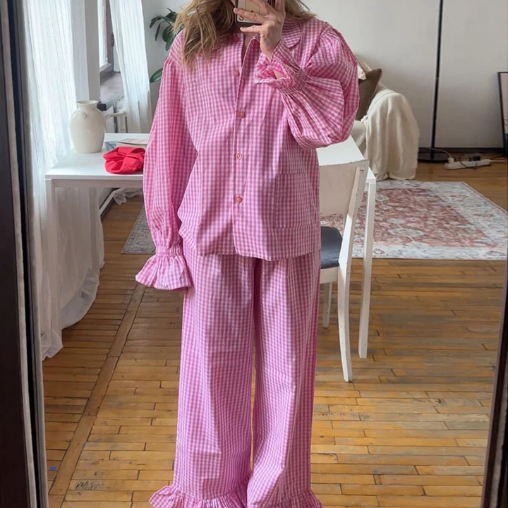 Person wearing a Pink Nova Sharp 2-Piece Set outfit in a room with wooden flooring and white furniture.