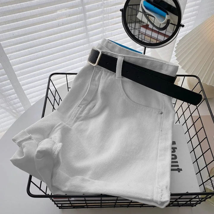 Outlaw Muse Wide-Leg White Denim Shorts with a black belt on a wire basket against a white background
