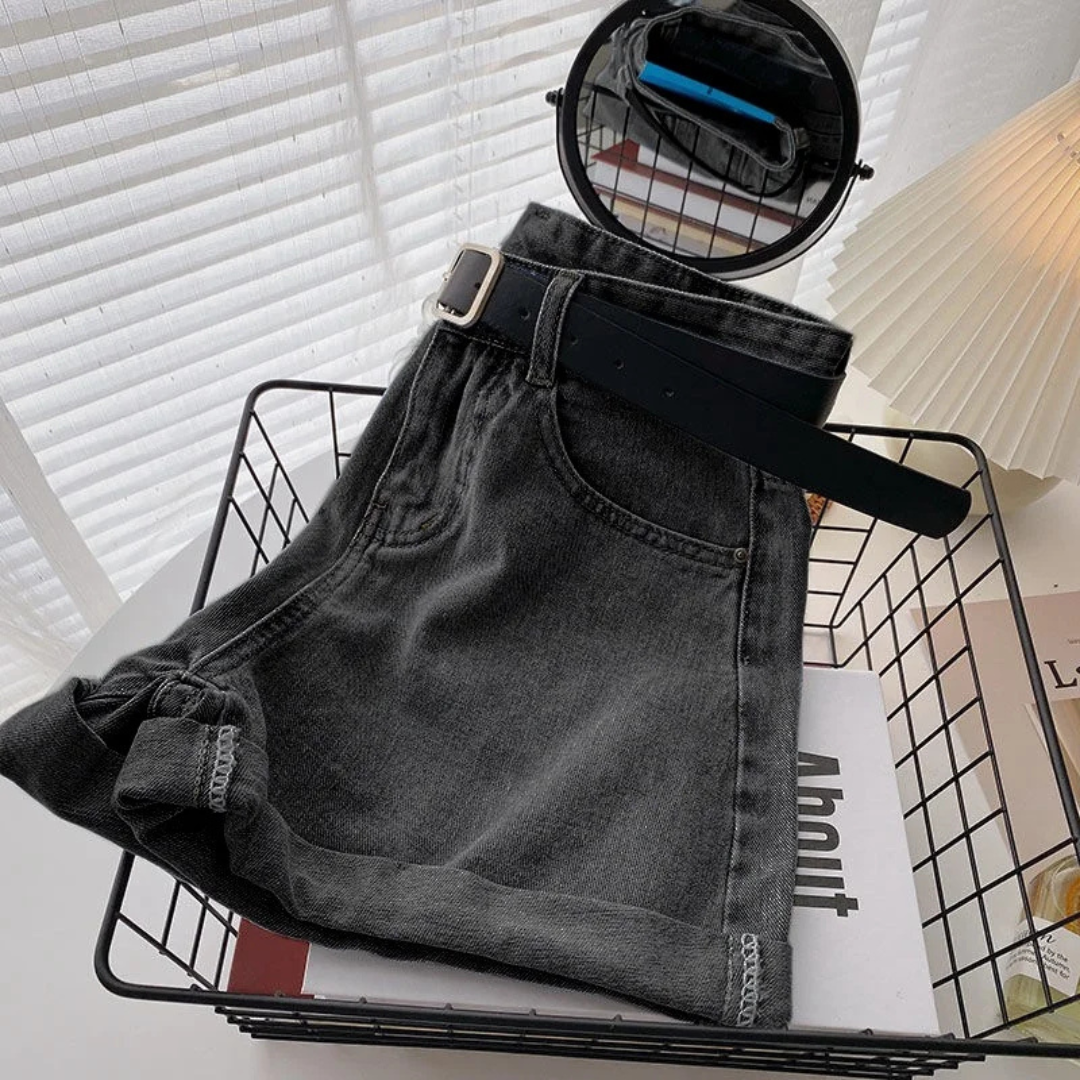 Outlaw Muse Wide-Leg Black Denim Shorts with a belt on a magazine