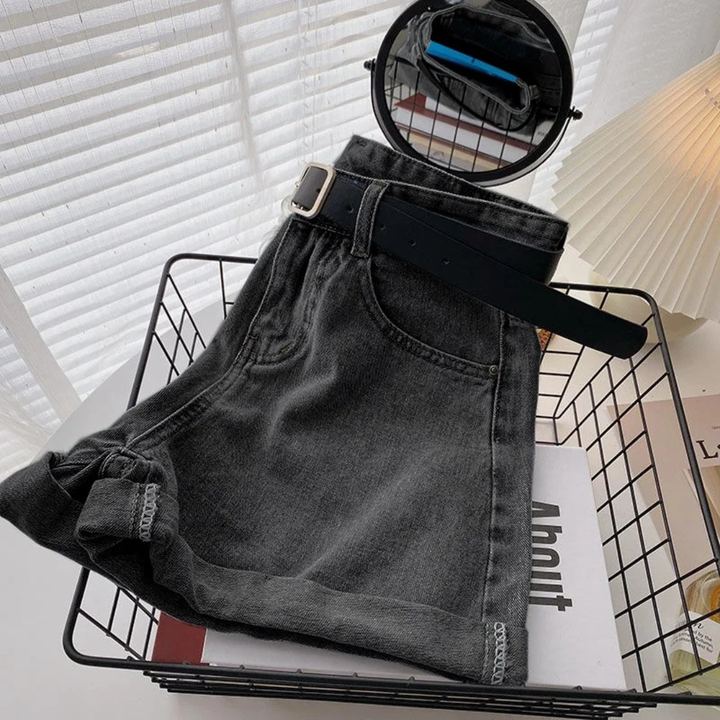 Outlaw Muse Wide-Leg Black Denim Shorts with a belt on a magazine