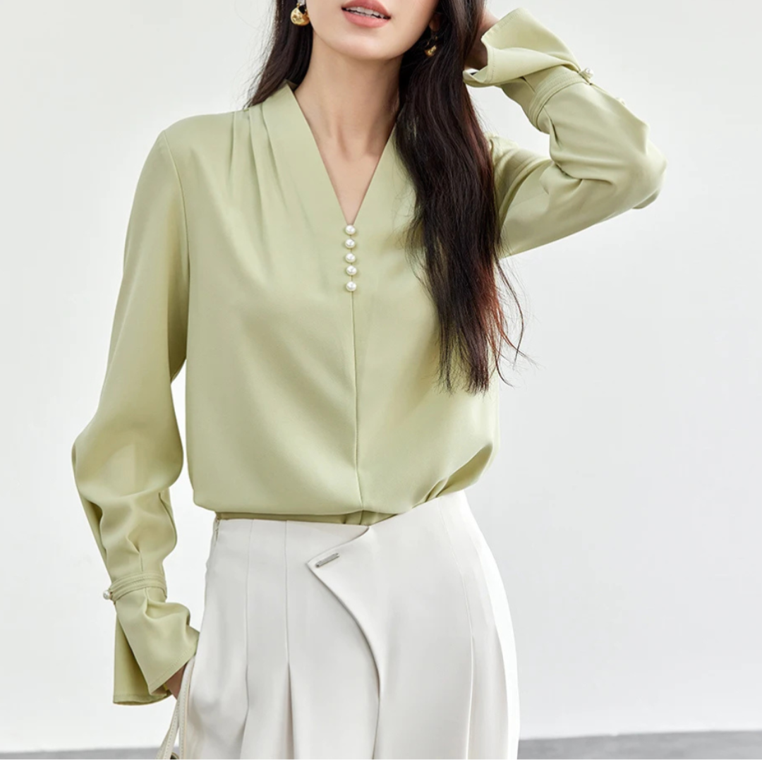 Woman wearing a light green blouse with a white background