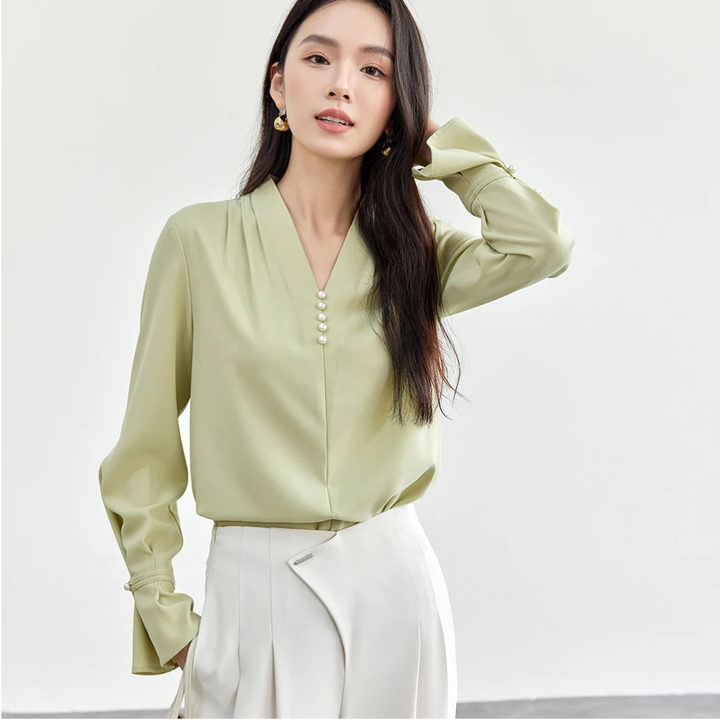 Woman wearing a light green blouse with a white background