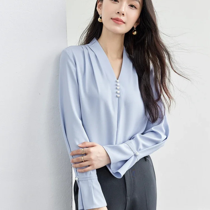 Woman wearing a light blue blouse against a white background