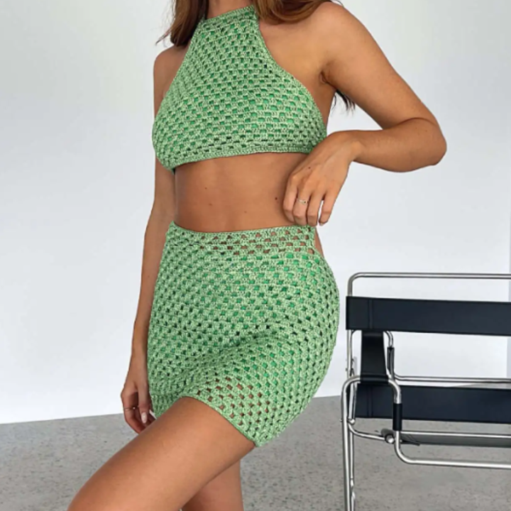 Person wearing a green crochet two-piece outfit with a chair in the background