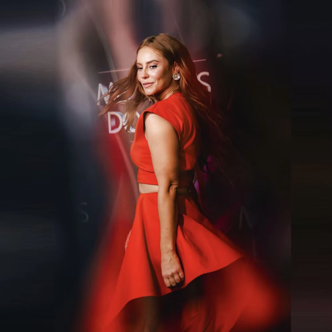 Woman in a red dress standing against a blurred background