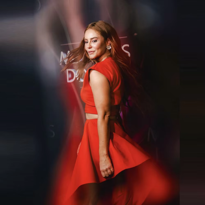 Woman in a red dress standing against a blurred background