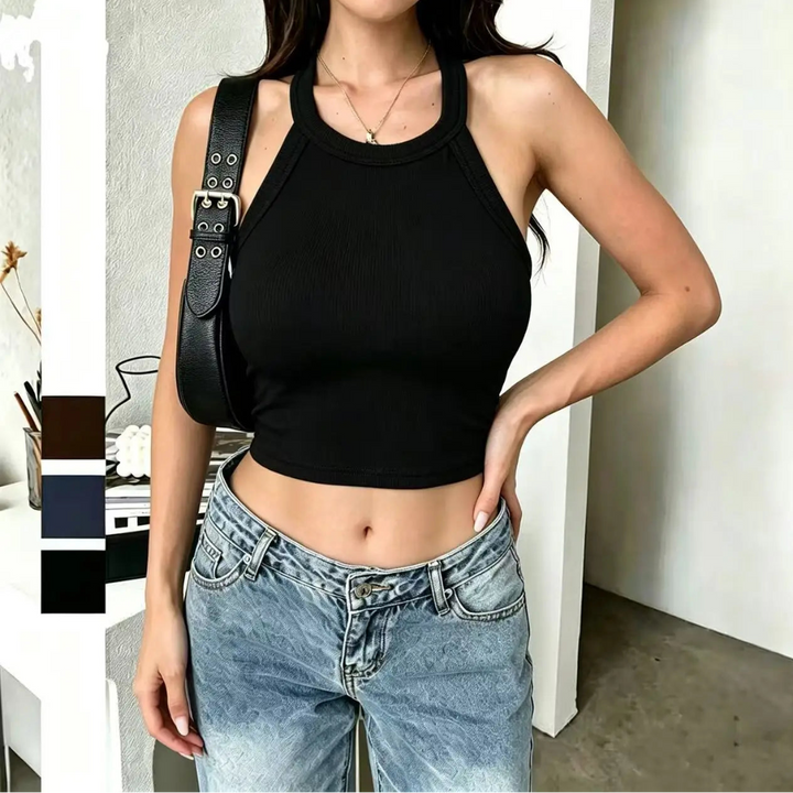 Person wearing a black tank top and blue jeans with a black bag over one shoulder.