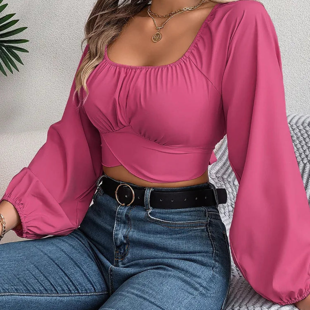 Person wearing a pink top and blue jeans sitting on a textured surface