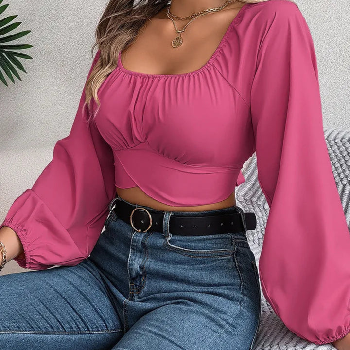 Person wearing a pink top and blue jeans sitting on a textured surface