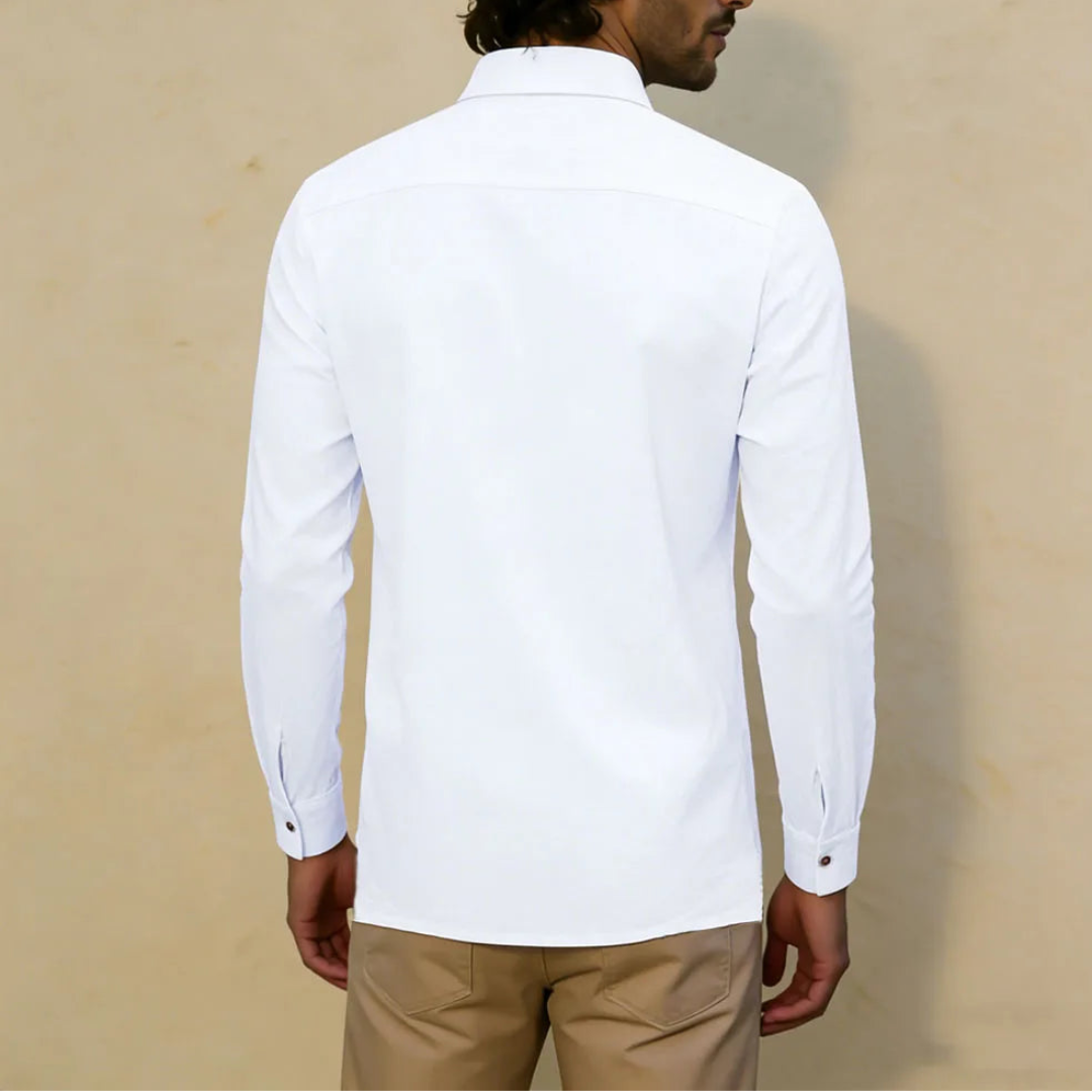 Man wearing a white shirt and beige pants against a beige background