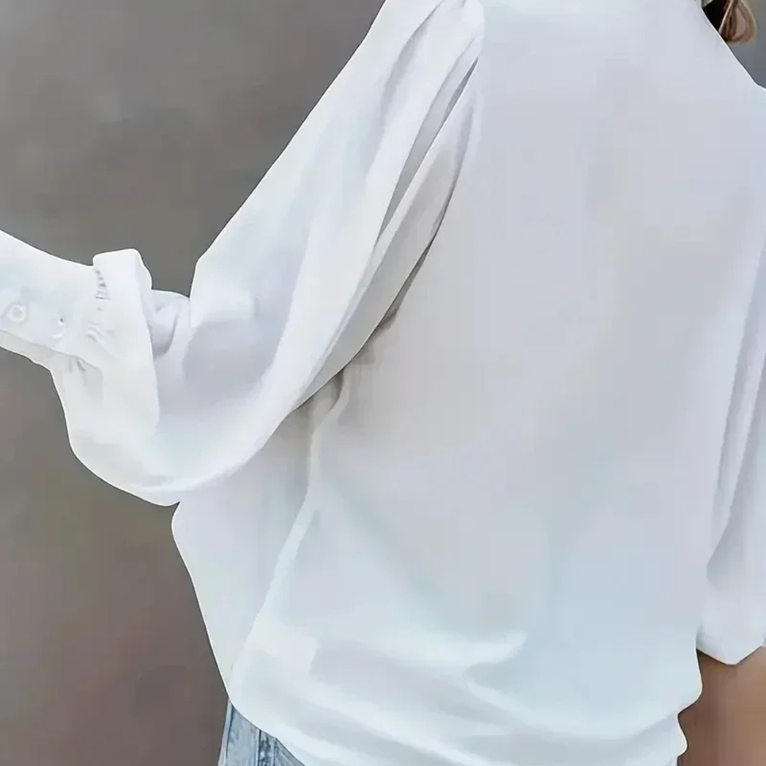 Close-up of a white Selestina Vogue Edge Plus Size Blouse with sheer sleeves against a neutral background