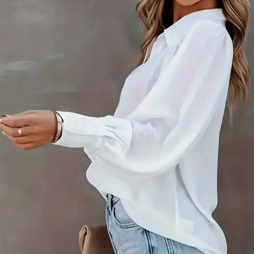 Person wearing a white Selestina Vogue Edge Plus Size Blouse and light blue jeans against a neutral background