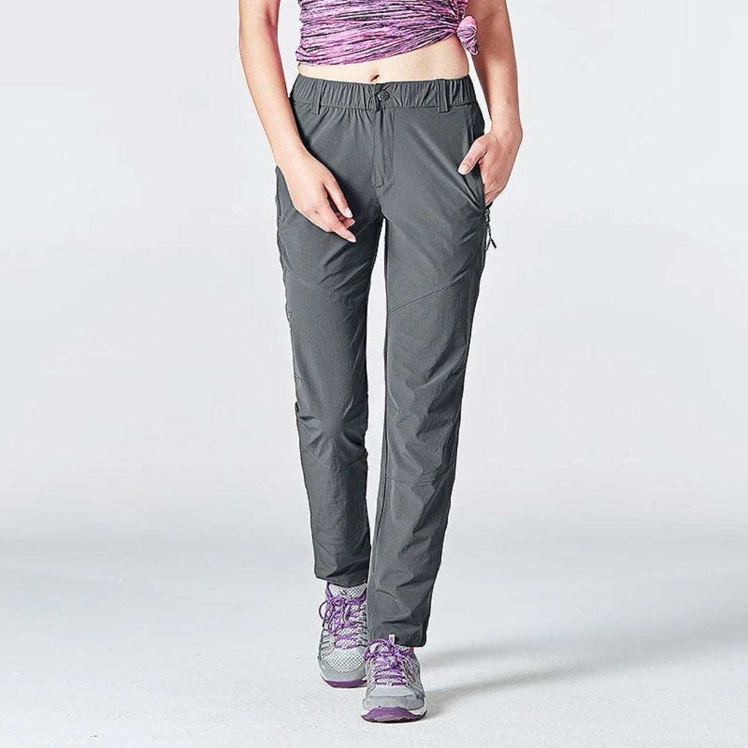 Person wearing gray pants and purple shoes on a white background