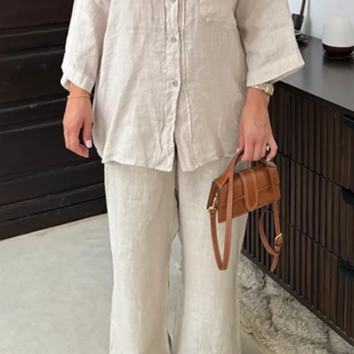 Person wearing a beige Vanta Femme Structured 2-Piece Set outfit holding a brown handbag indoors.