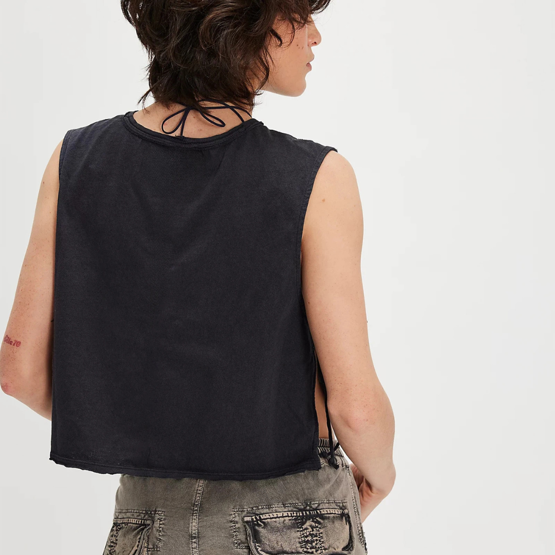 Person wearing a black Vanta Grace Vintage Crop Top and gray pants on a white background