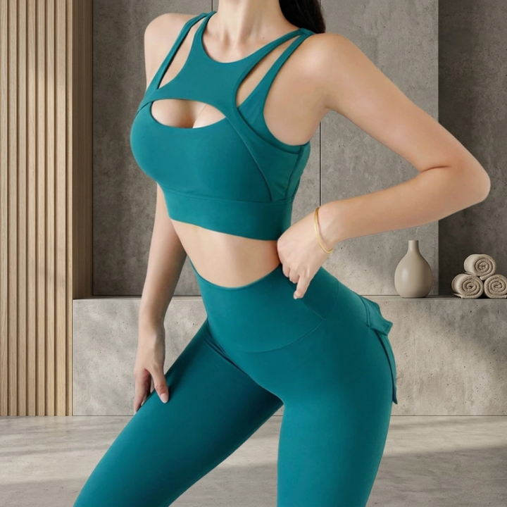 Person wearing a green sports bra and leggings set in a neutral setting.