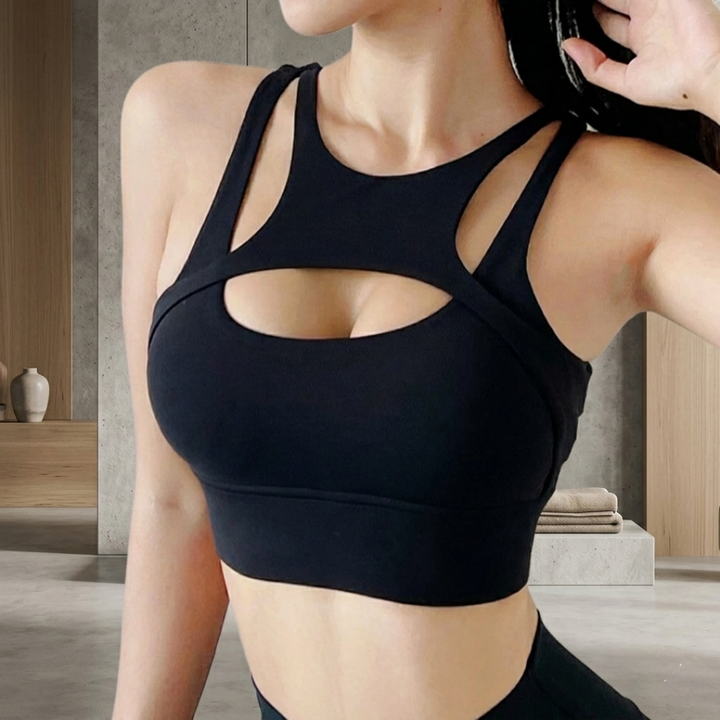 Person wearing a black sports bra in a neutral indoor setting