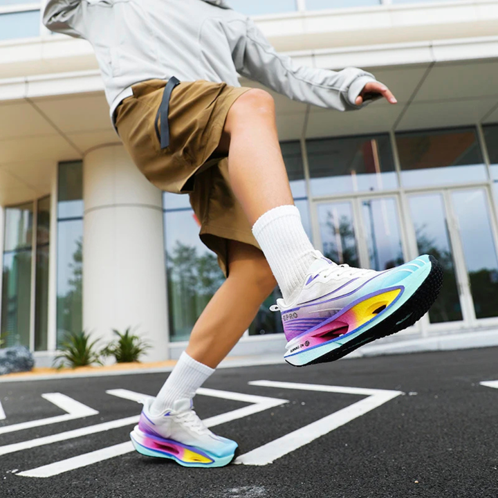 Person wearing Blue Purple Vortex Strike Carbon Running Shoes on a street with a building in the background