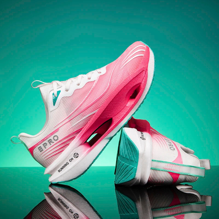 Pink Vortex Strike Carbon Running Shoes on a reflective surface with a teal background
