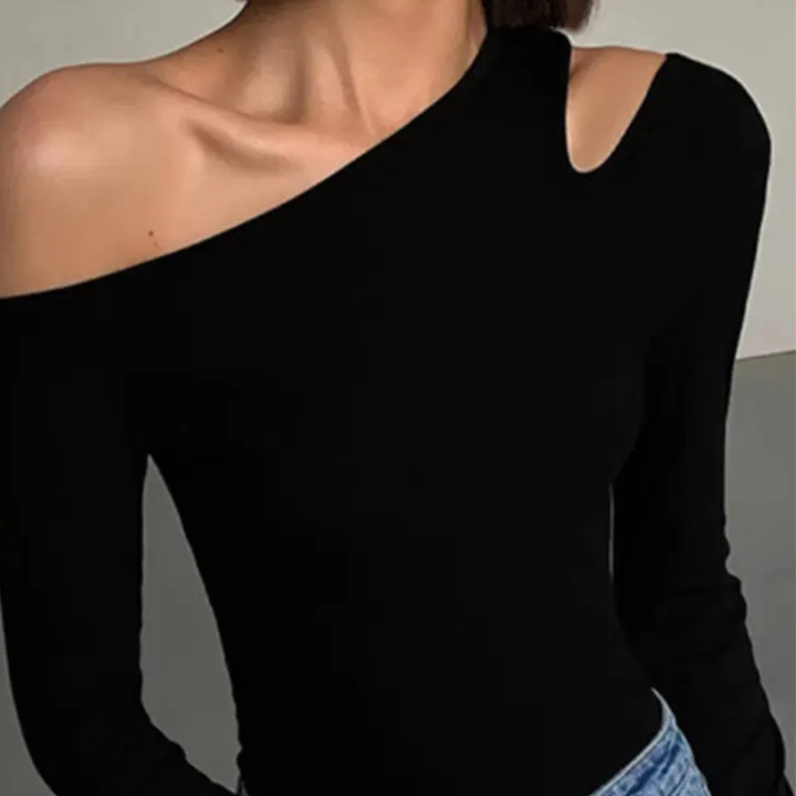 Black one-shoulder top worn by a person on a neutral background