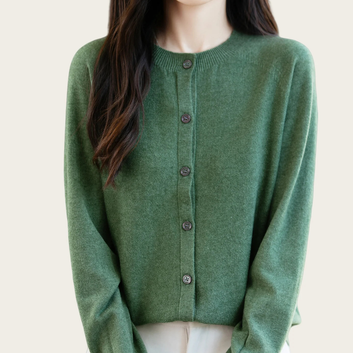 Green cardigan worn by a person on a plain background
