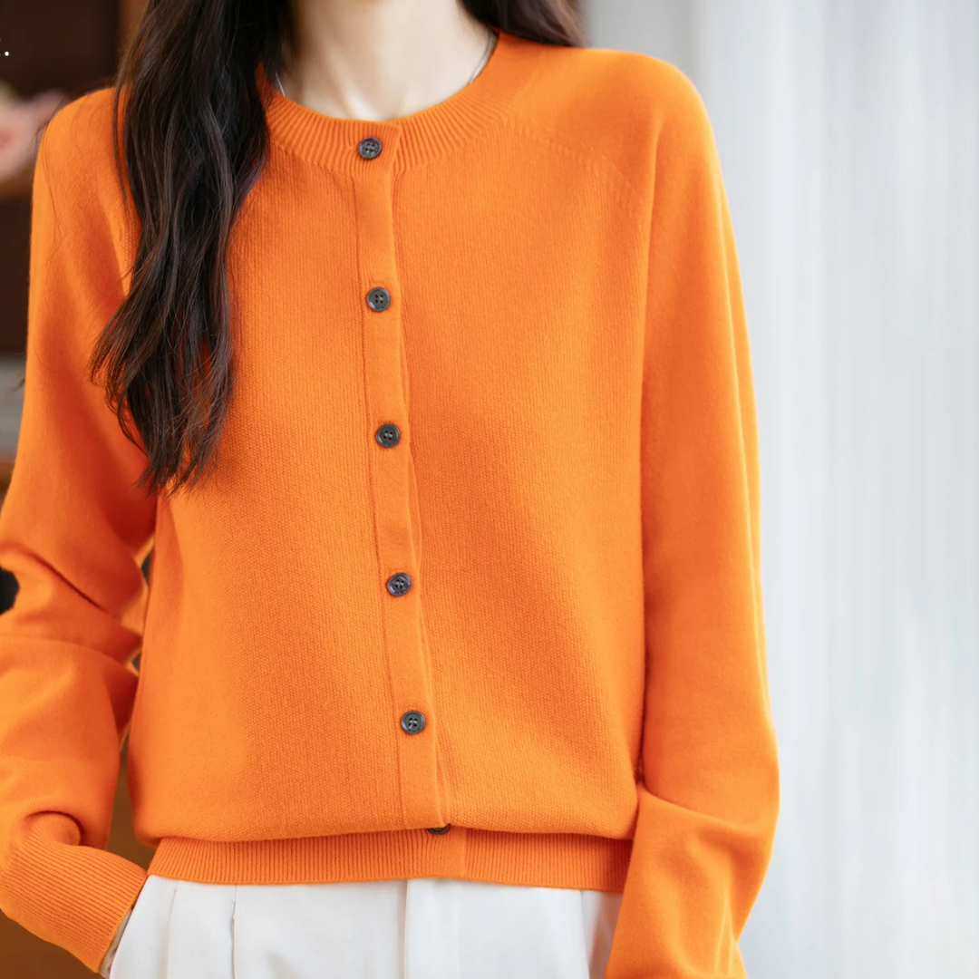 Orange cardigan worn by a person with a blurred background