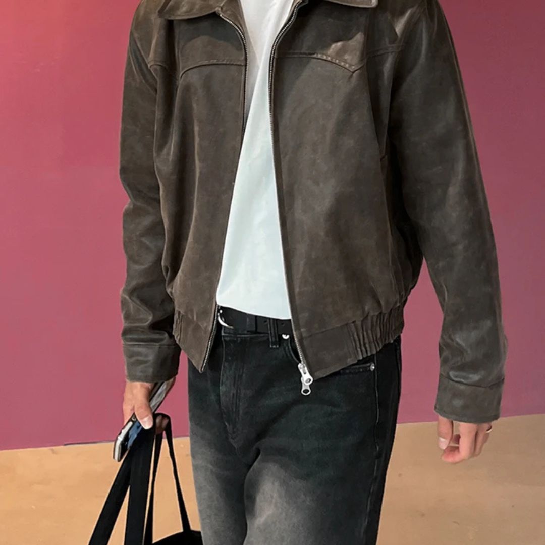 Person wearing a brown leather jacket against a pink background